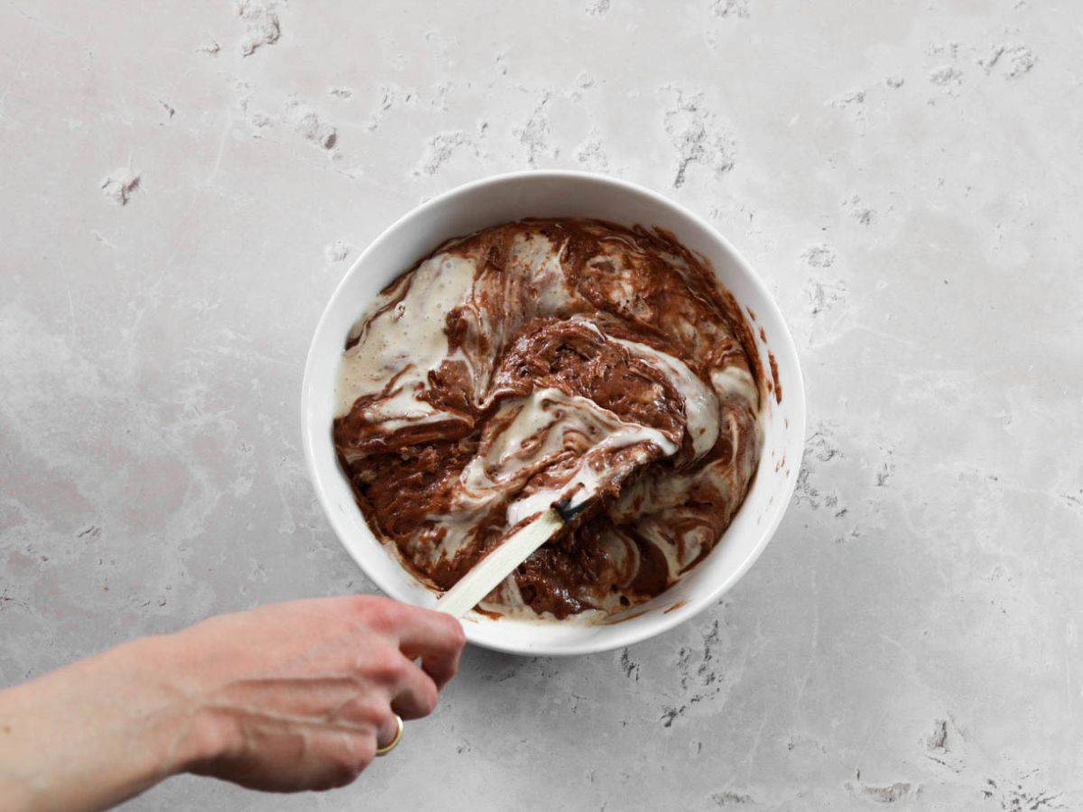 Batter for chocolate sourdough cupcakes in a white bowl.