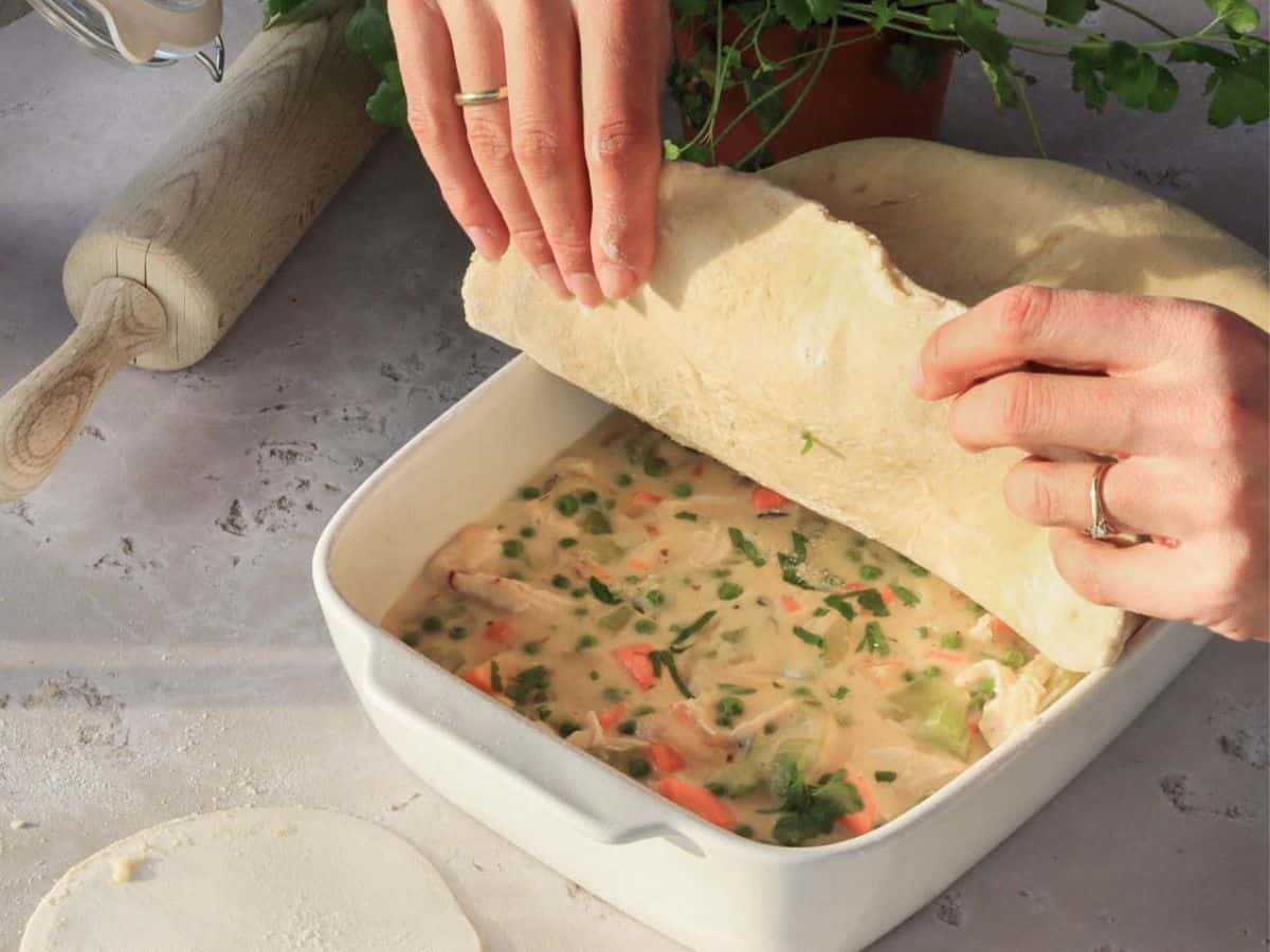 Placing the sough on sourdough discard chicken pot pie.
