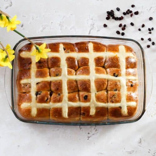 Twelve hot cross buns with flowers.