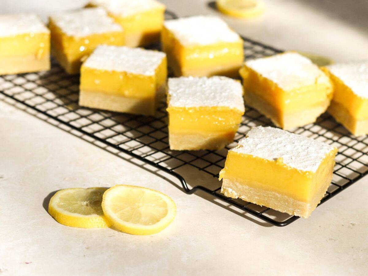 Sourdough discard lemon bars on a cooling rack with lemon slices