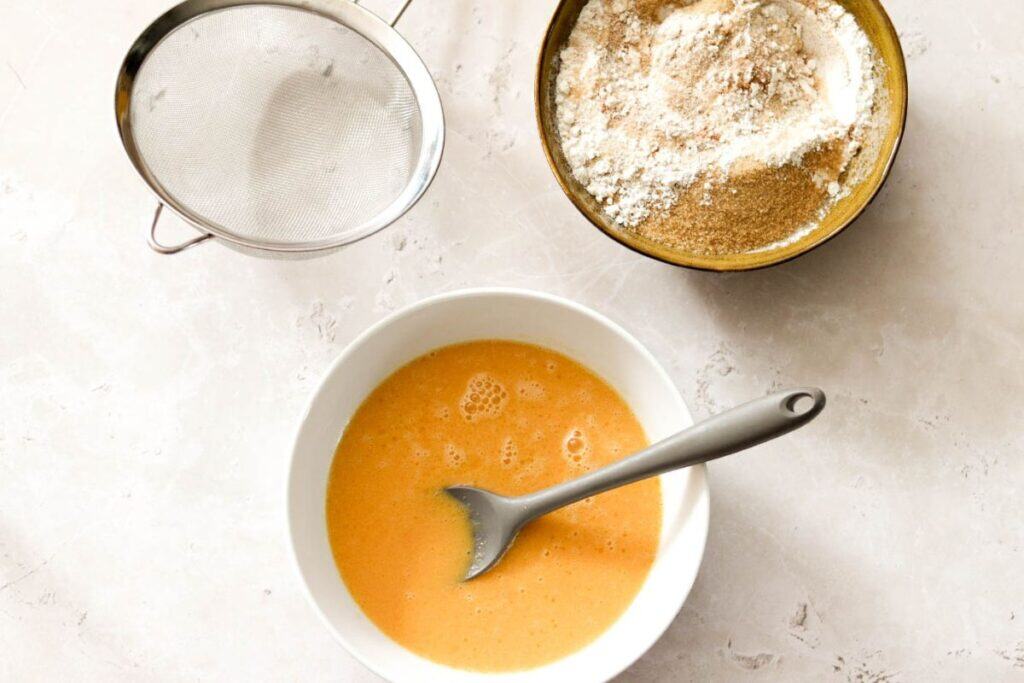 Mixing the wet ingredients for sourdough muffins with pumpkin puree.