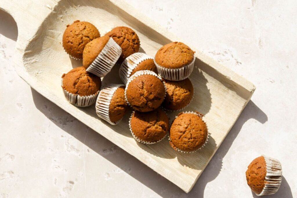 Sourdough pumpkin muffins on a white serving board.
