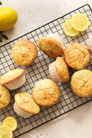 Lemon poppy seed sourdough muffins on a wire rack.