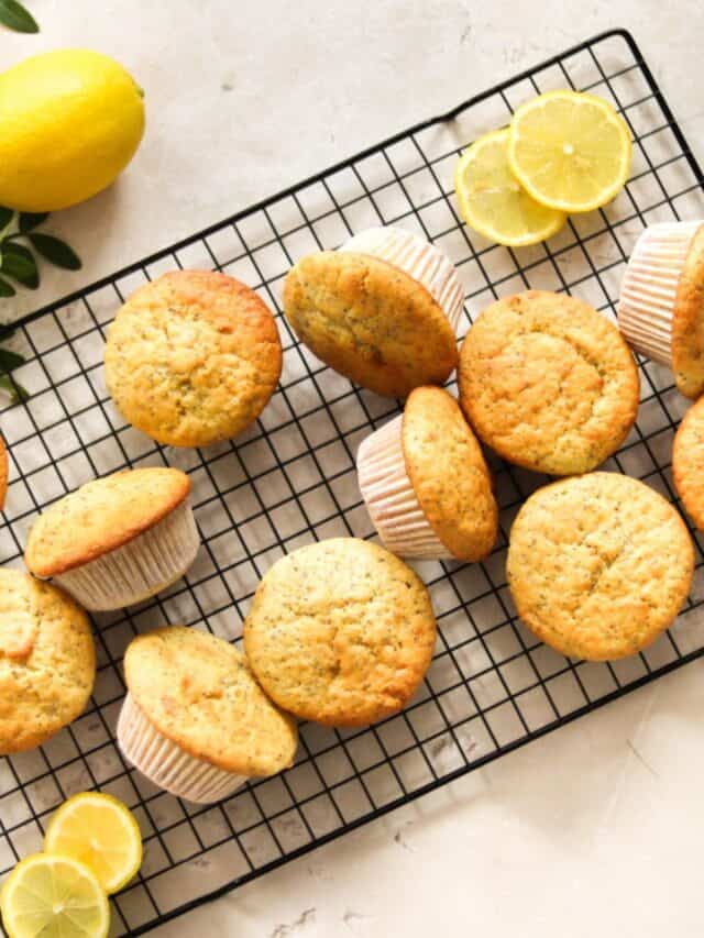 Lemon poppy seed sourdough muffins on a wire rack.