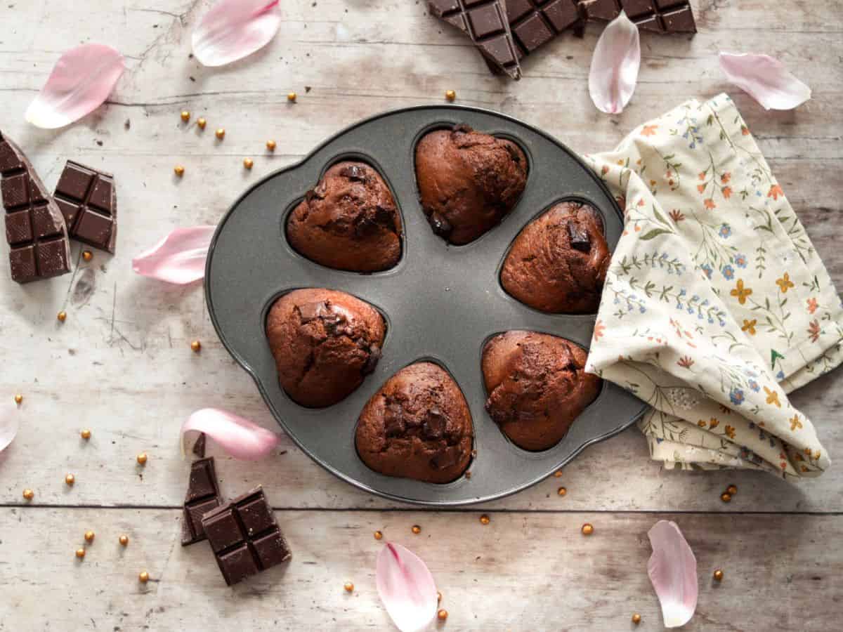 Double chocolate sourdough muffins in a muffin tin.