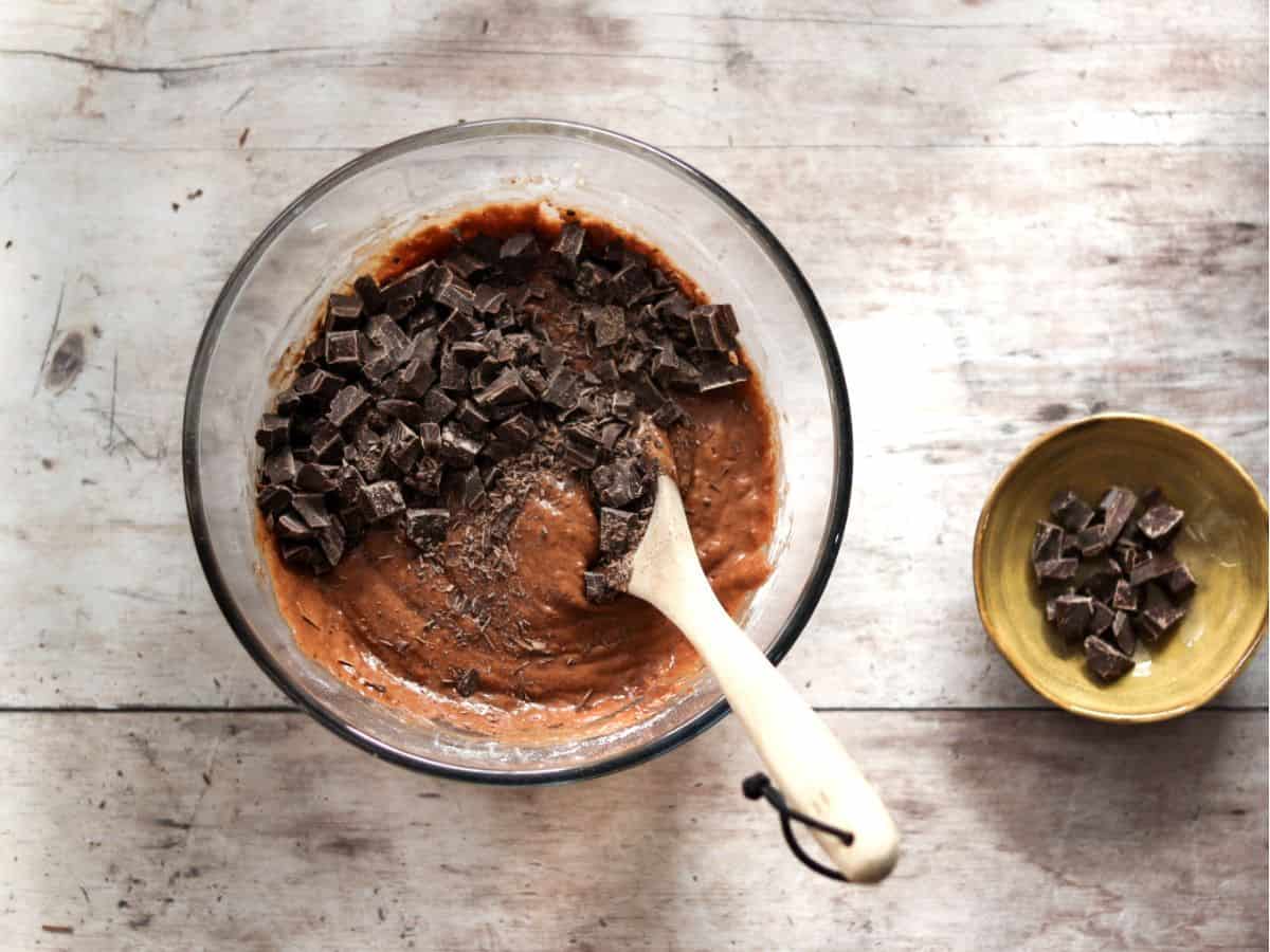 Adding chocolate to the batter for double chocolate sourdough muffins.