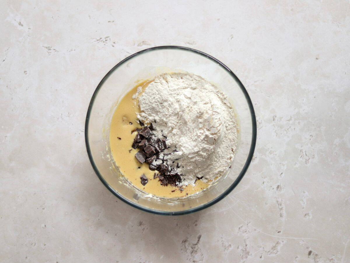 Adding chocolate and flour to the wet ingredients.