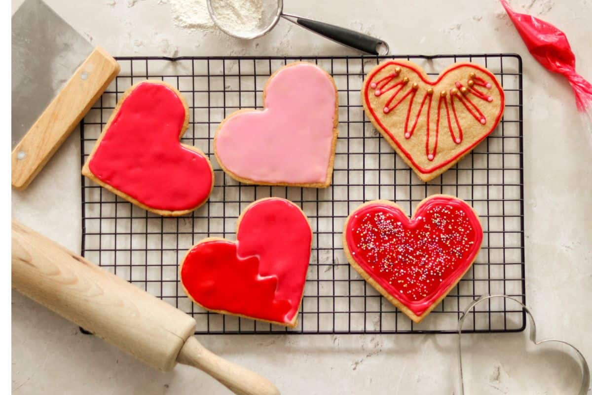 Five heart-shaped Valentine's Day cookies on a wire rack.
