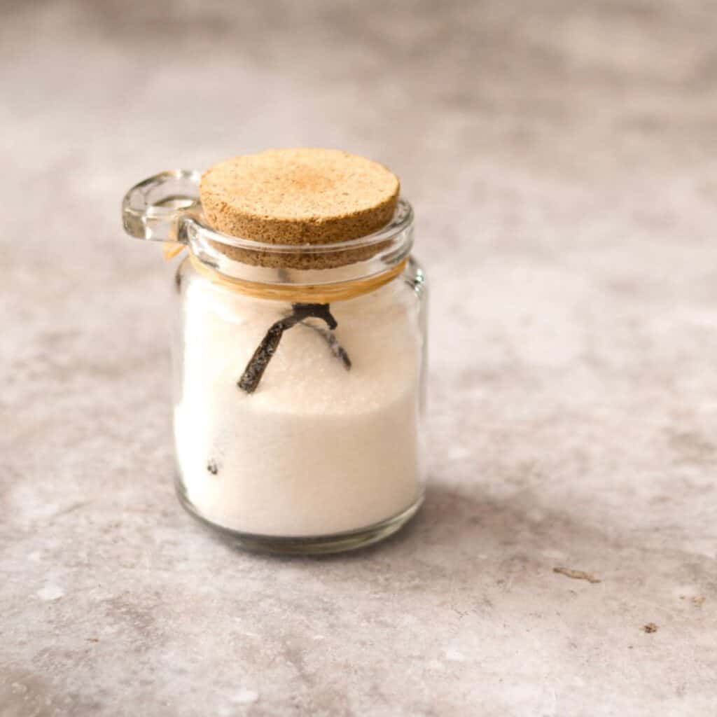 Homemade vanilla sugar in a glass jar.