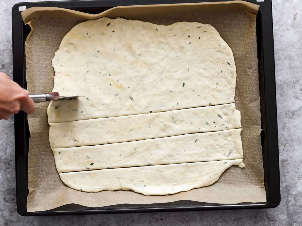 Cutting the dough in to square crackers.