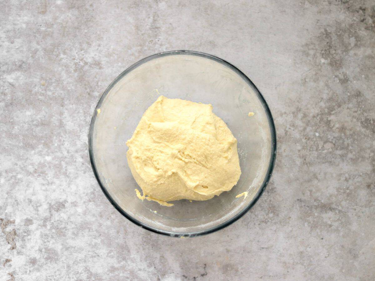 Dough for sourdough hot dog buns in a glass bowl.