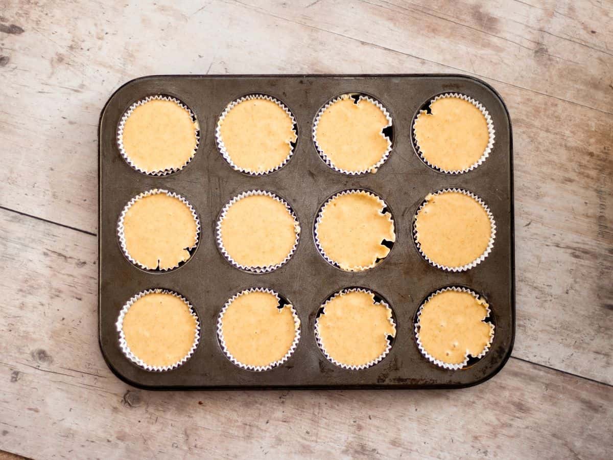 Adding the batter to muffin liners.